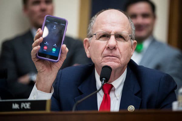 Man at microphone holding up a phone