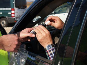 person in car being handed a breathalyzer